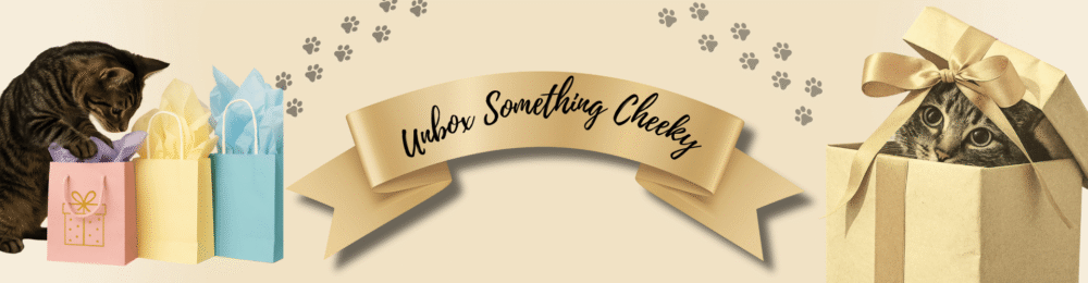 Tabby cat exploring pastel gift bags and another cat peeking from a box, with a gold ribbon reading ‘Unbox Something Cheeky’.