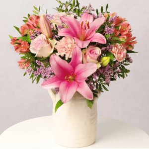 Strawberry Sunset from Bunches showing soft pink roses, blush carnations, strawberry pink lily and lush greenery