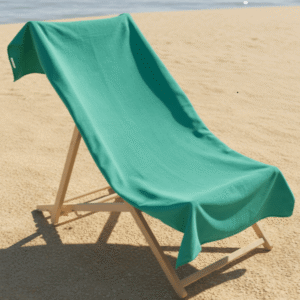 OHS plain green microfibre beach towel draped over wooden beach chair on sand