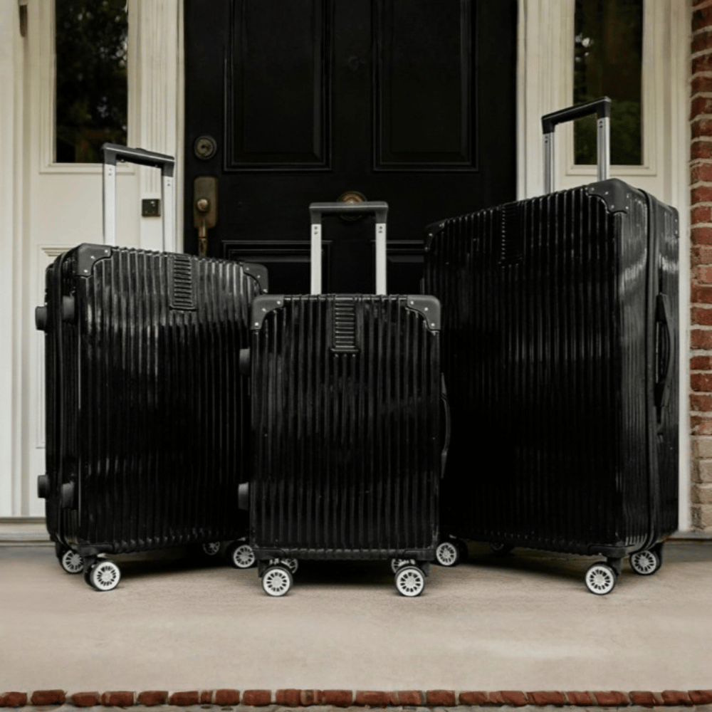 Black hard shell suitcase set with four wheels and telescopic handles in three sizes for travel