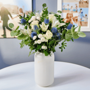 Blossoming Gifts Blue Serenity Flower Bouquet from Card Factory showing white roses, a white lily, white pom poms and blue thistle with greenery.