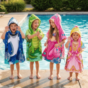 FloatBuds Character Poncho Towels showing Shark, Crocodile, Mermaid and Princess designs worn by children beside a swimming pool