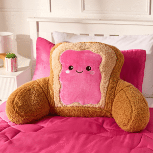 OHS Toast pink and brown character cuddle cushion on a bed
